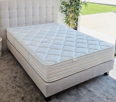 un lit sur lequel est posé un matelas dans une pièce