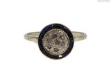 un gros plan d'une bague sur laquelle est posée une pièce de monnaie