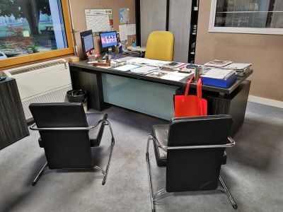 a desk with two chairs and a laptop on it