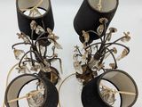 pair of black lamps with gold trim and crystals on each of them