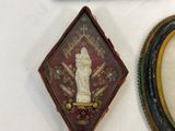 three framed pictures and a picture of a woman are on a table
