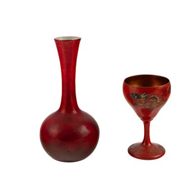 un vase rouge et un verre à vin posés l'un à côté de l'autre