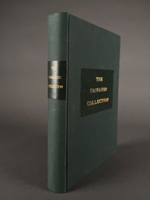 an old book with a black cover sitting on a table