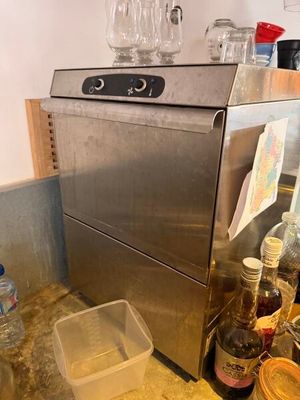 un lave-vaisselle en acier inoxydable posé sur un plan de travail dans une cuisine