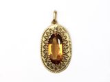 un gros plan sur un pendentif en or orné d'une citrine facettée