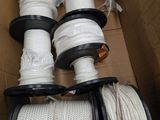 plusieurs rouleaux de corde blanche dans une boîte en carton munie de poignées noires