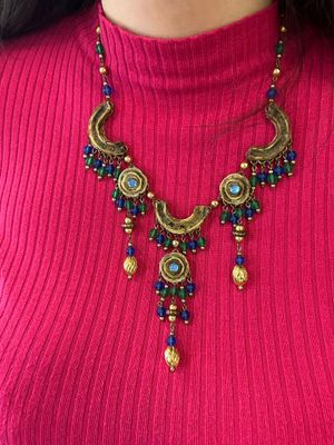 un gros plan sur une femme portant un pull rose et un collier