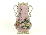 un vase rose sur lequel sont peints un oiseau et des fleurs