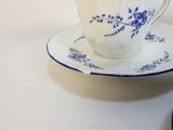 a tea cup and saucer on a white table