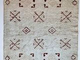 a white and brown rug with crosses and arrows on it