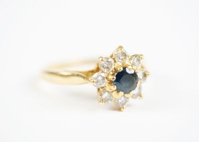 a close up of a gold ring with a blue sapphire and white diamonds