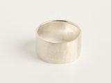 gros plan d'une bague en argent sur une surface blanche
