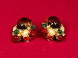 pair of gold tone earrings with multi colored stones and pearls
