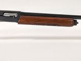 un vieux fusil de chasse avec un canon en bois et un socle en acrylique transparent