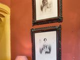 trois tableaux encadrés accrochés au mur au-dessus d'une commode
