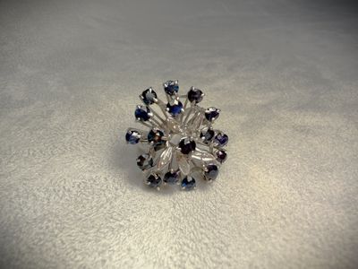 an image of a ring with blue and white crystals on a white surface