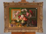 a painting of flowers in a vase on a easel