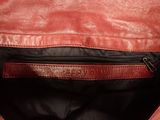 the inside of a red leather bag with a zipper
