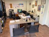 un bureau avec des chaises et un ordinateur posé dessus, dans une pièce