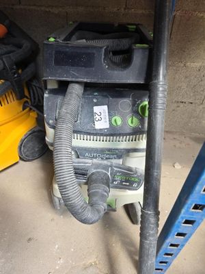 une photo montrant un plumeau et un souffleur dans un garage