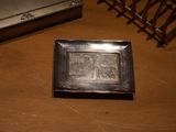 a silver plate with a picture on it sitting on a table
