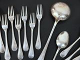 a lot of silver spoons and forks on a black plate
