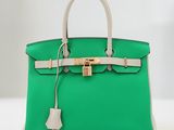 un sac Hermès vert avec un fermoir doré sur la poignée