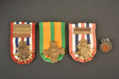 trois médailles et une médaille posée sur un fond noir