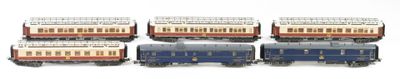 four miniature trains that are lined up on a white surface