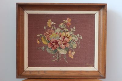 tableau représentant un bouquet de fleurs dans un cadre en bois posé sur une table