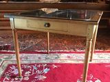 a small table with a glass top on a red rug