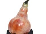 a figurine of a pear on a black plate
