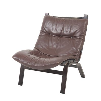 fauteuil en cuir marron avec des pieds en métal noir et un repose-pieds