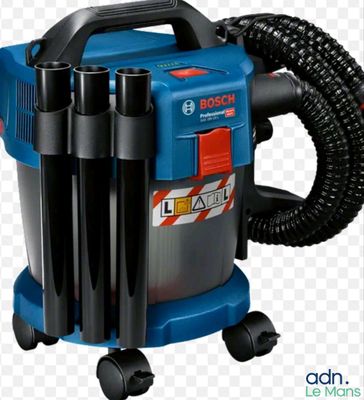 l'aspirateur est bleu et noir, avec un tuyau qui y est raccordé