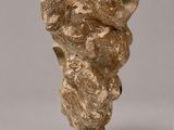 a close up of a stone vase with a face on it