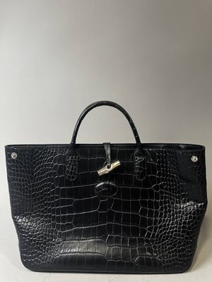 un sac à main en cuir de crocodile noir sur fond blanc