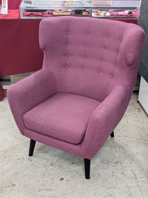 une chaise violette dans un magasin, avec une table rouge en arrière-plan