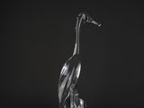 a clear glass sculpture of a crane on a black background
