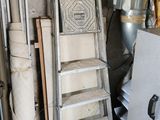 a ladder leaning against a wall next to a pile of items