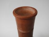 a brown vase sitting on top of a white table