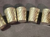 four pieces of silver metal are arranged in a row on a gray surface