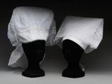deux têtes de mannequin noires recouvertes d'un tissu blanc