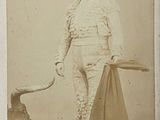 une vieille photo d'un homme avec un taureau en arrière-plan