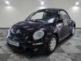 une photo d'une Coccinelle Volkswagen noire garée sur un sol à damier