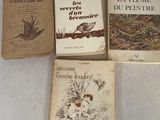 Quatre livres sont posés sur une table recouverte d'une nappe blanche.