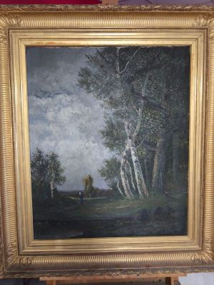 une peinture à l'huile représentant un paysage avec des arbres, dans un cadre doré, posée sur un chevalet en bois