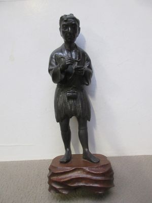 une statue représentant un homme debout sur un rocher