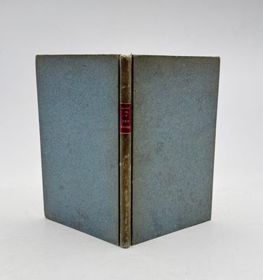 un vieux livre posé sur une table blanche à côté d'un mur blanc