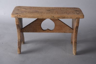 un petit banc en bois avec un trou sur le dessus