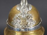 a silver and gold helmet with a crest on it